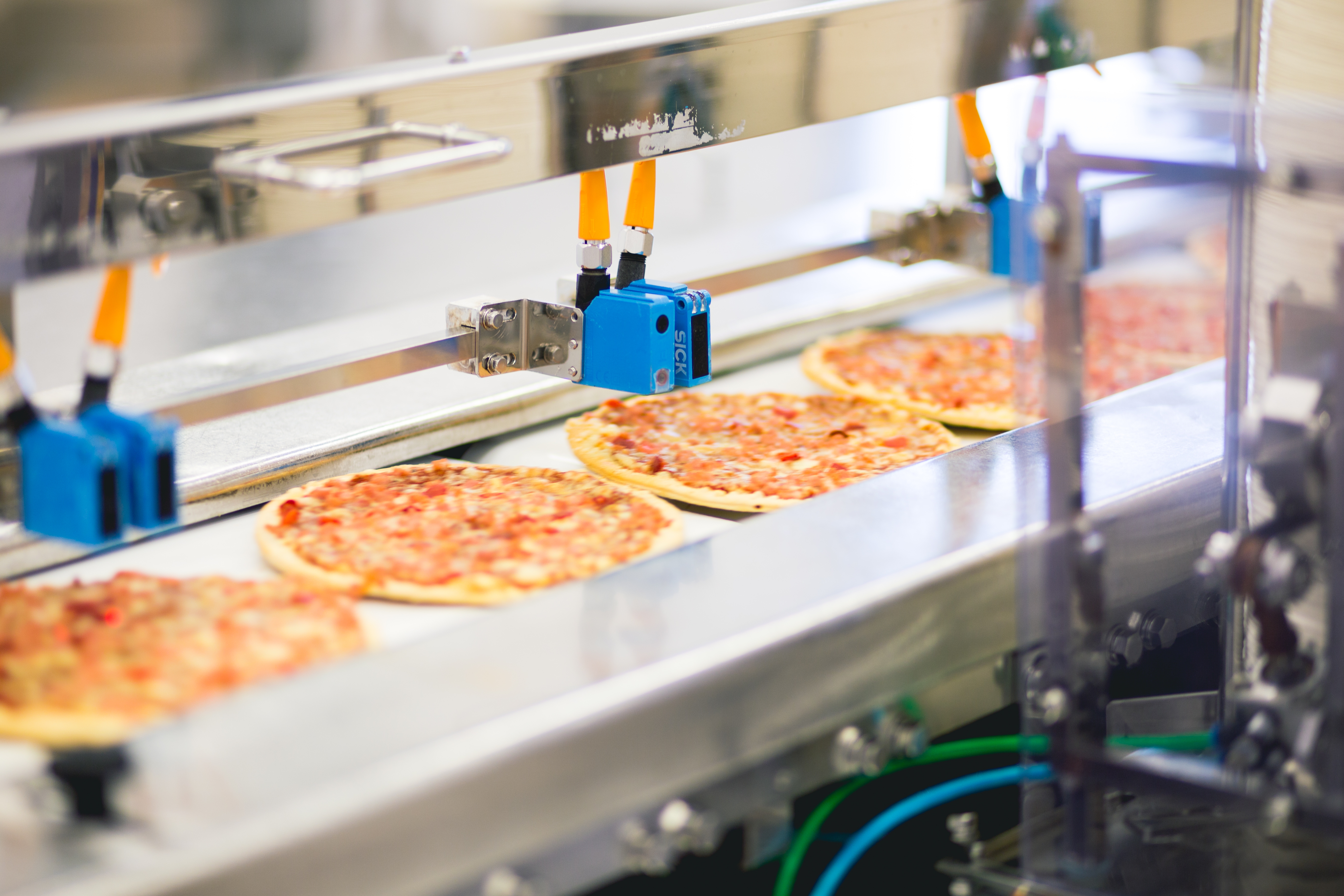 pizza on a conveyor belt in a food production facility