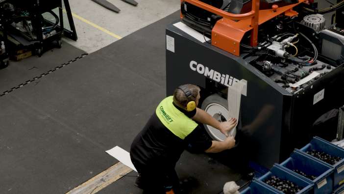 Combilift factory floor worker labeling forklift