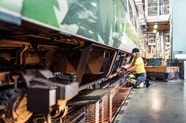 photo of a worker tending to parts on a train