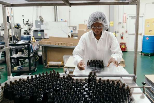 photo of a frontier co op packager in a uniform sorting bottles