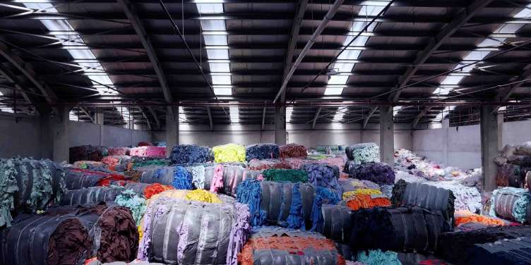 large spools of textiles sitting in a big factory room