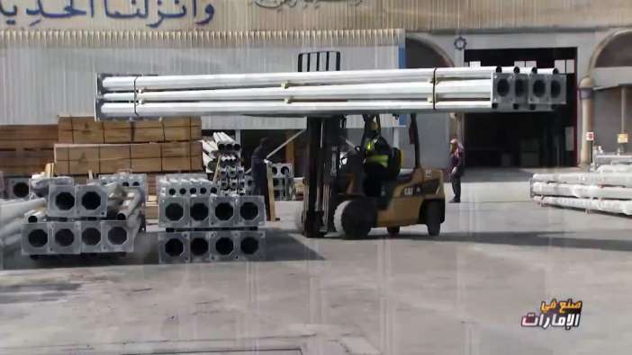 photo of a forklift carrying large pipes