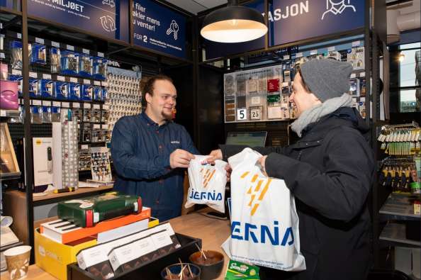 photo of a man handing jernia bags over a store counter