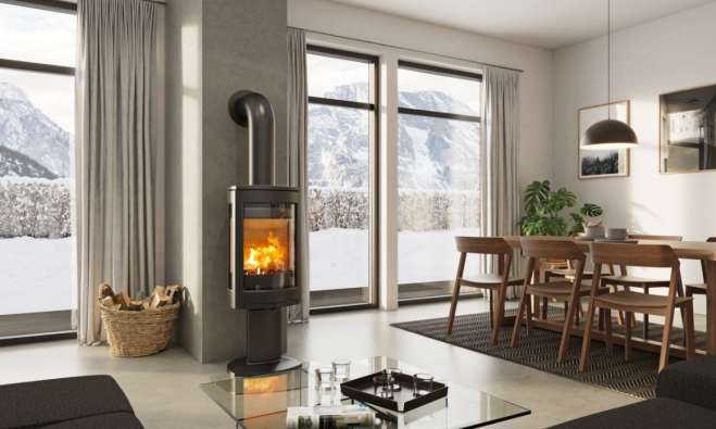 photo of a cozy modern living room with a fireplace and large windows looking out into the snow