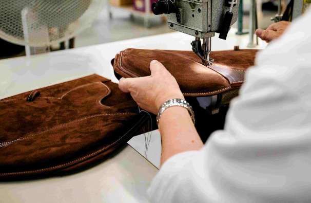 photo of a saddlemaker sewing a saddle together