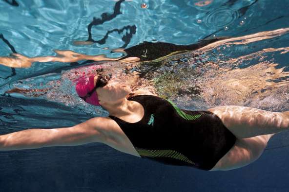 underwater photo of a swimmer in the water swimming laps