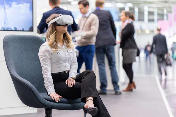 woman wearing virtual goggles seated people standing