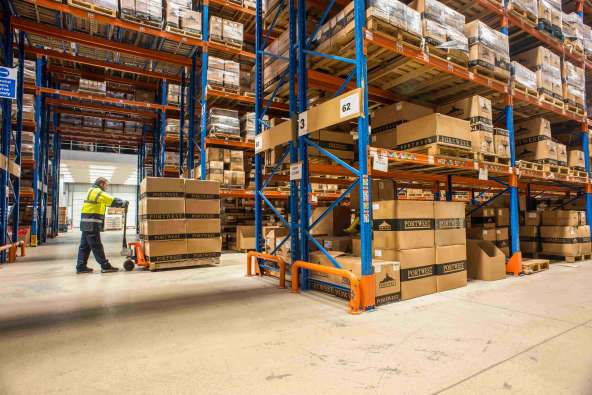 photo inside of a large warehouse with a man pushing boxes around