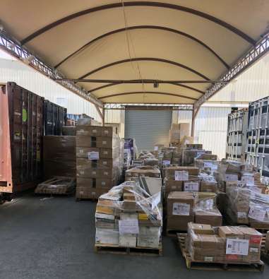 photo of the outside of a warehouse with boxes piled up