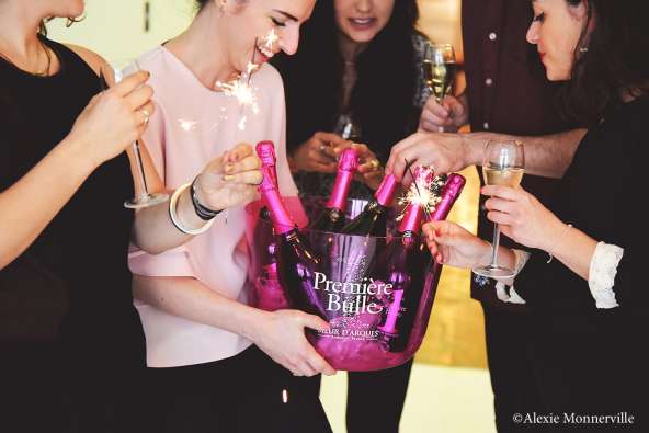 photo of people in office attire celebrating with a bucket of champagne