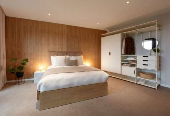 photo of a modern apartment bedroom with carpet and wood walls