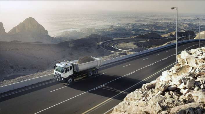 aerial photo of a truck on a highway carrying dirt in the truck bed