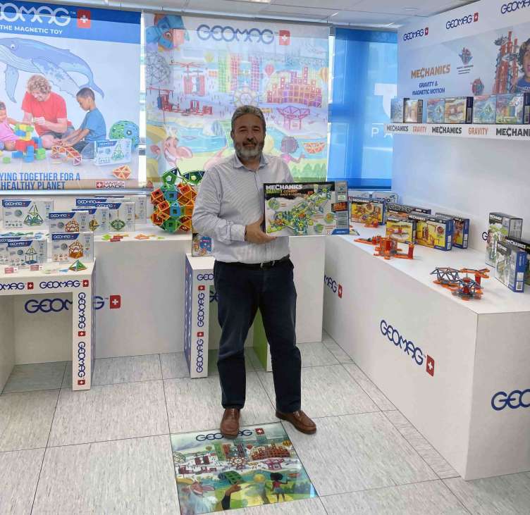 photo of a man posing with a toy in a toy store