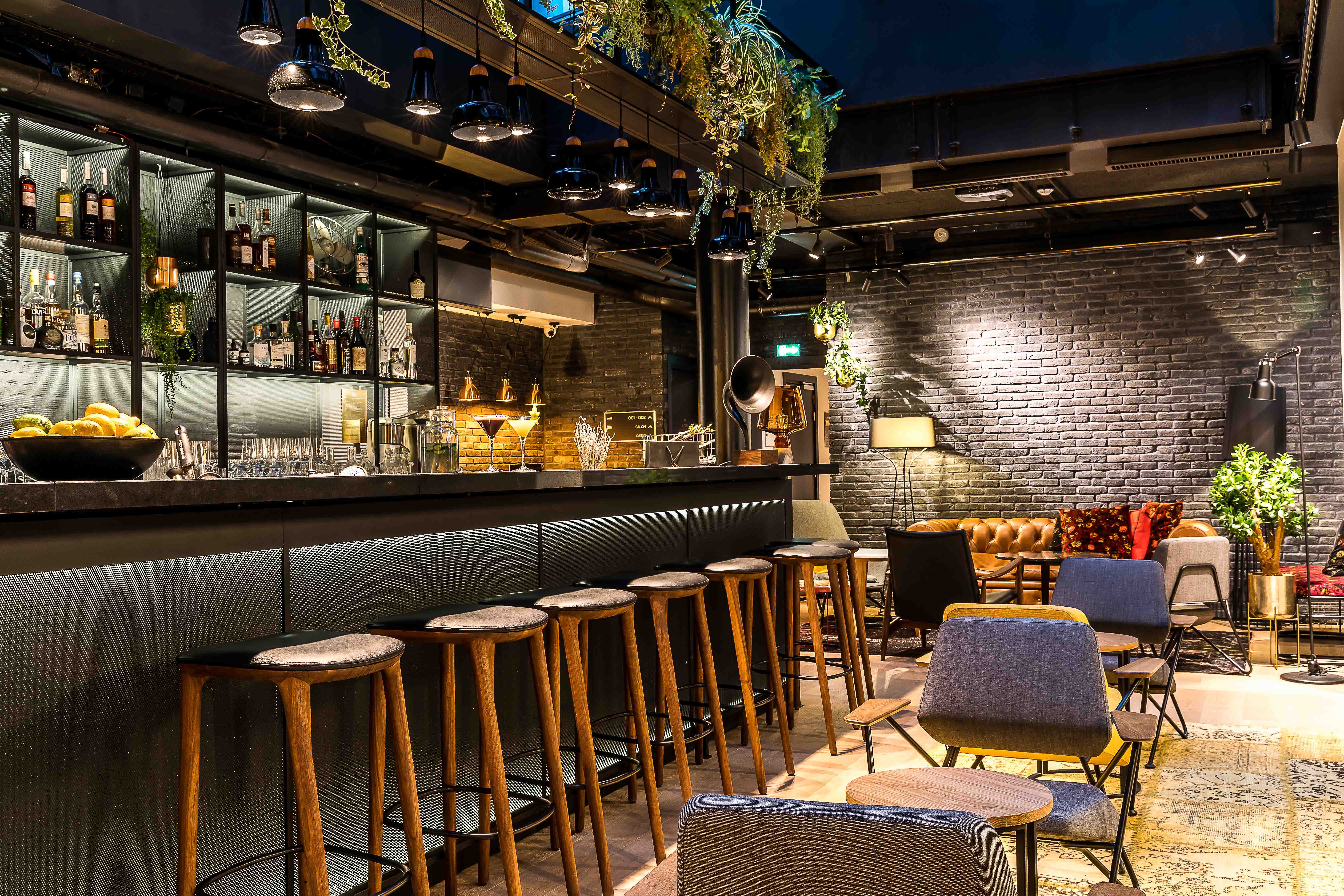photo of a modern bar with black decor and wooden barstools