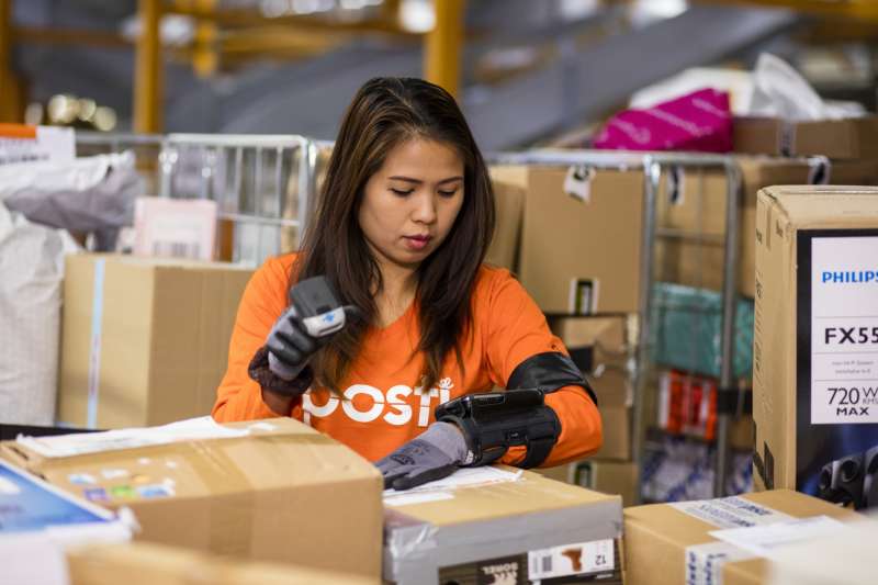 posti worker taping up boxes in a warehouse