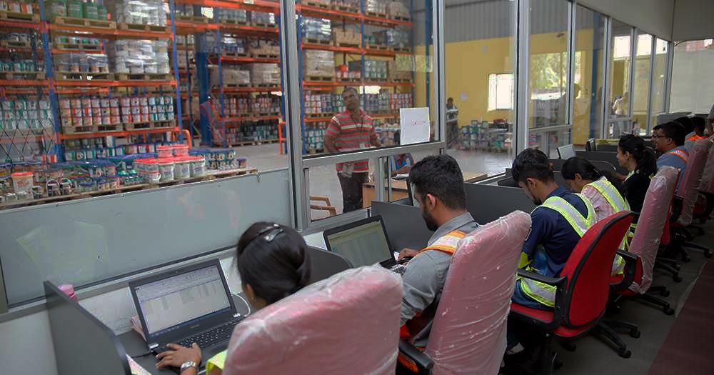 photos of logistics workers on computers in a large warehouse